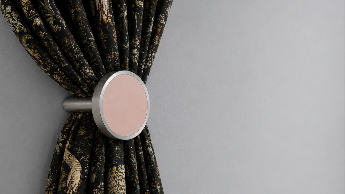 Patterned curtain gathered by a decorative tieback in a refined interior